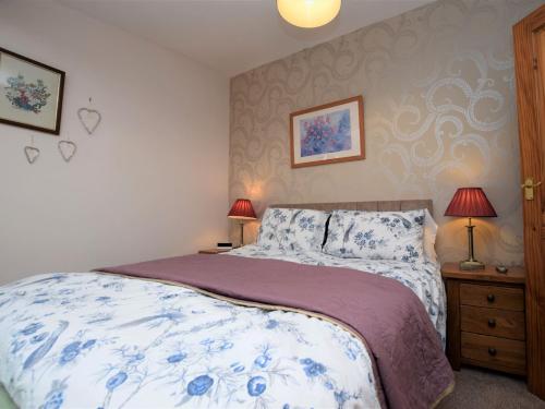 a bedroom with a bed with blue and white sheets at 2 Bed in Bideford 78252 in Parkham