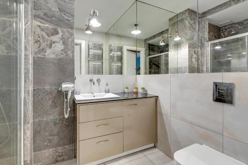 a bathroom with a sink and a shower at Staywin Prime Apartments Chmielna in Gdańsk