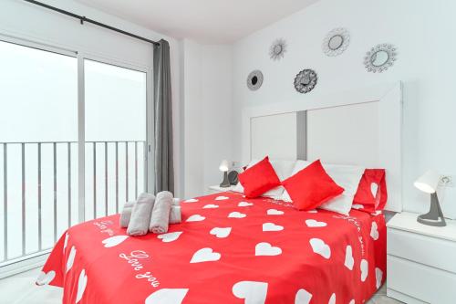 a bedroom with a red and white bed with red pillows at Nerja Boutique 204 Beauty in Nerja