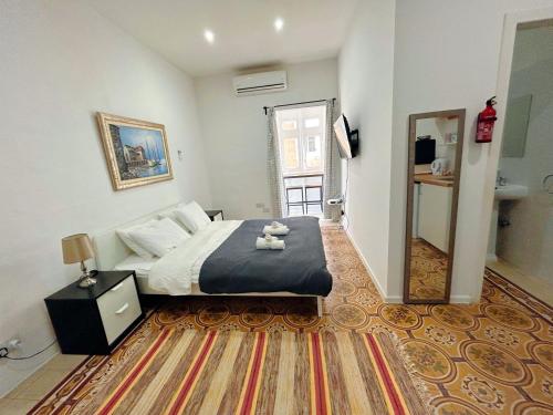 una camera con un letto e un grande specchio di San Francisco Studios Valletta a Floriana