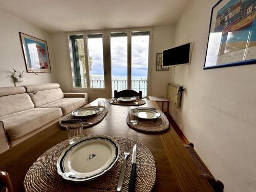 uma sala de estar com uma mesa e um sofá em [Bilocale Frontemare] magnifica terrazza em Alassio