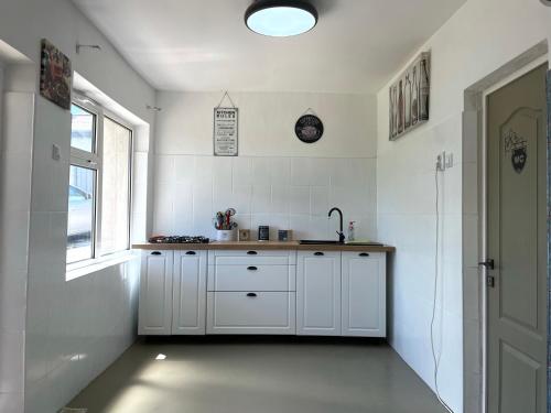 a white kitchen with a sink and a window at Countryside Home 