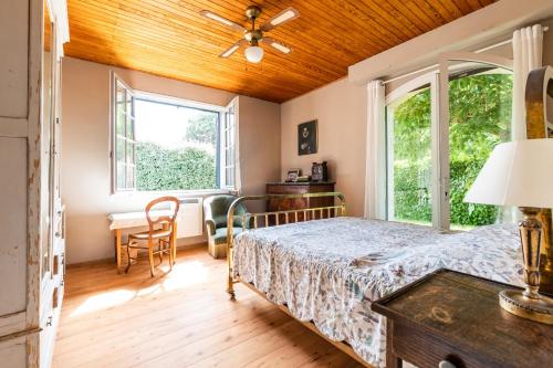 Schlafzimmer mit einem Bett und einem Fenster in der Unterkunft Sejour detente en famille avec piscine in Andernos-les-Bains