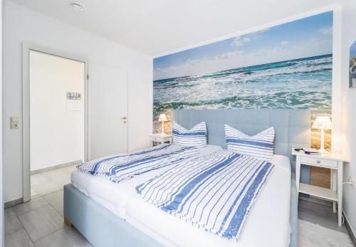 1 dormitorio con 1 cama y una pintura del océano en Ferienpark Sierksdorf App 334 - Strandlage en Sierksdorf