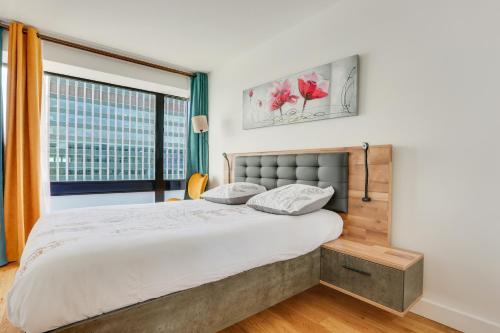 une chambre avec un grand lit et une fenêtre dans l'établissement Paris luxury Apartment 75m2 with Eiffel Tower View, metro 1 min, parking, à Paris