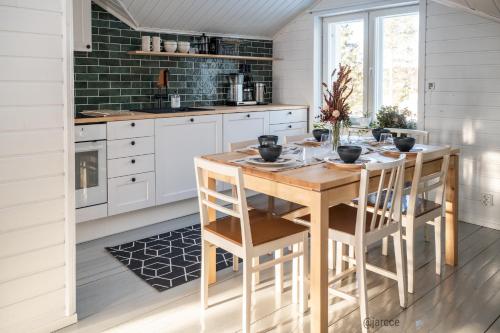 a kitchen with white cabinets and a wooden table at Huoneisto Toloppa in Ranua