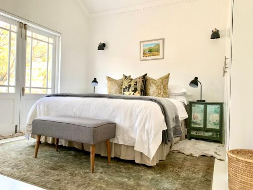 a white bedroom with a large bed and a window at Dream On Cottage in Prince Albert