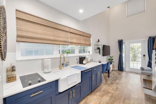 a kitchen with blue cabinets and a window at SHELLY - Cozy 1 bedroom tiny home with pool in Dunedin