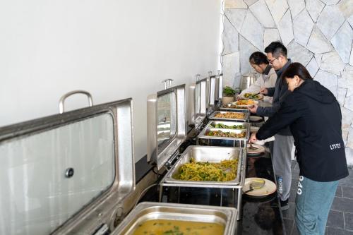 a group of people preparing food in a buffet line at Purna in Pokhara