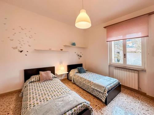 a bedroom with two beds and a window at [5 TERRE]The Terrace on the Gulf - Parking / Wi-fi in Lavagna