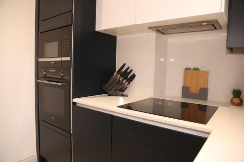 cocina con fregadero y fogones horno superior en Star London Edgware Road 2-Bed Haven, en Londres