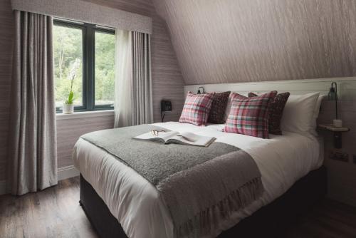 een slaapkamer met een bed met twee boeken erop bij Ardlui Retreat Lodge 4 in Arrochar