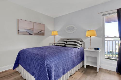 1 Schlafzimmer mit einem Bett mit einer lila Bettdecke und 2 Lampen in der Unterkunft The Cuckoo's Nest in North Topsail Beach