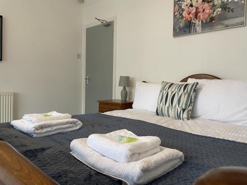 a bedroom with two towels on a bed at Elm, Large 5 Bedrooms, Sleeps 10 With Parking in Birmingham