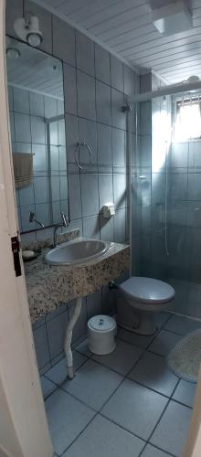 een badkamer met een wastafel, een toilet en een spiegel bij Amplo apartamento para aluguel diário numa das melhores praias de SC. in Meia Praia