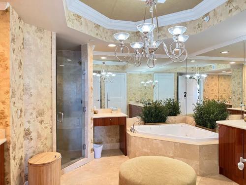 里維拉海灘的住宿－Ritz Carlton Luxurious Residence on Singer Island，带浴缸和吊灯的大浴室