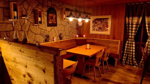 a dining room with a wooden table and chairs at Hotel Mira in Sedrun