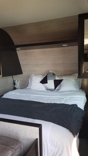 a bedroom with a large bed with a wooden headboard at Kyan caravan in Muhya