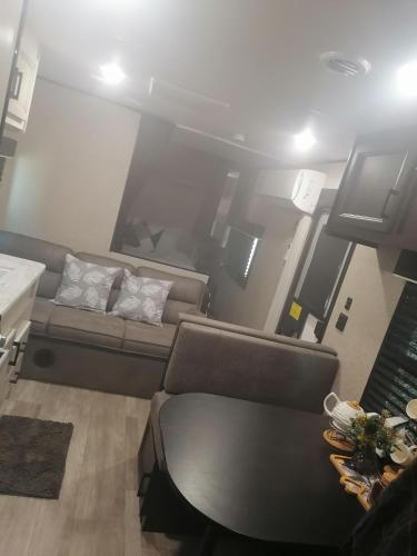 a living room with a couch and a table at Kyan caravan in Muhya