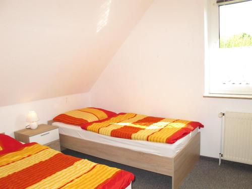 a bedroom with two beds and a window at Ferienhaus SONNE HORS100 in Wiarden