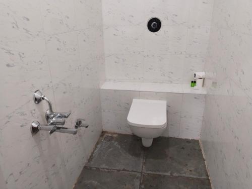 a bathroom with a white toilet in a stall at Rebel de Pondiche'ry in Pondicherry