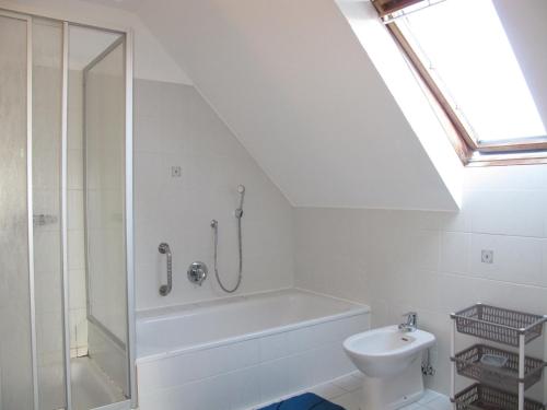 a bathroom with a bath tub and a toilet at Ferienhaus SONNE HORS100 in Wiarden