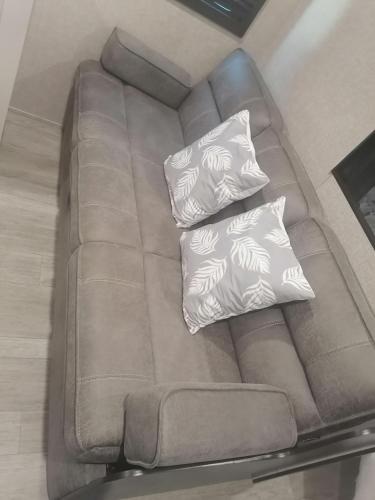 a brown couch with two pillows on it at Kyan caravan in Muhya