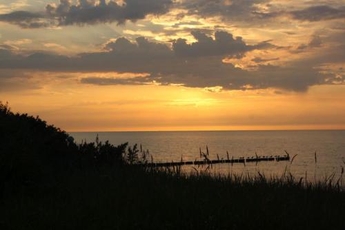 a sunset over a body of water with a pier at Pension Ostsee-Strand in Börgerende-Rethwisch