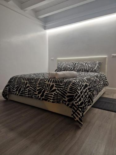 a black and white bed in a white room at Space Suite Marina in Cagliari