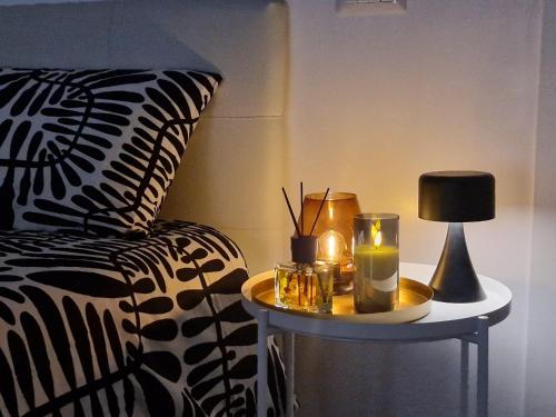 a table with a lamp and a side table with a bed at Space Suite Marina in Cagliari