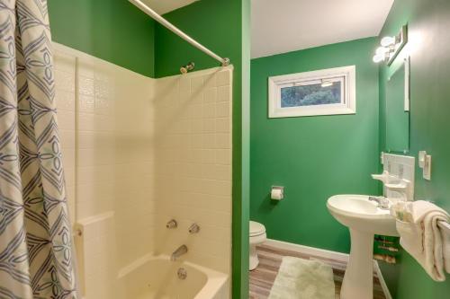 baño con paredes verdes, aseo y lavamanos en Riverfront Hot Springs Cabin with Private Hot Tub!, en Hot Springs