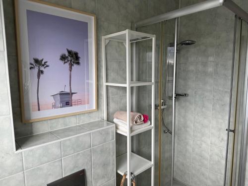 a bathroom with a shower and a towel shelf at Pension Ostsee-Strand in Börgerende-Rethwisch