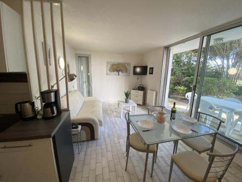 une cuisine et un salon avec une table et des chaises dans l'établissement Sol-y-Days jardins du couchant, à La Grande Motte