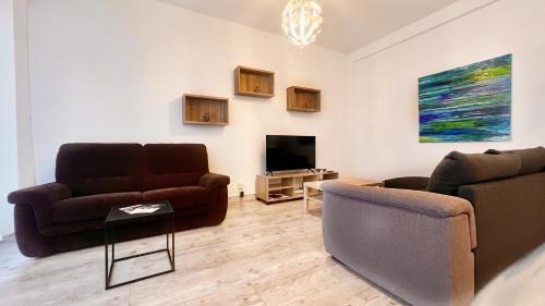 un salon avec deux canapés et une télévision dans l'établissement La Vague Douce, à Nice