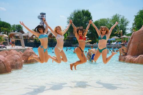 4 chicas saltando al agua en un parque acuático en Studio Centrale Pacengo di Lazise, en Lazise