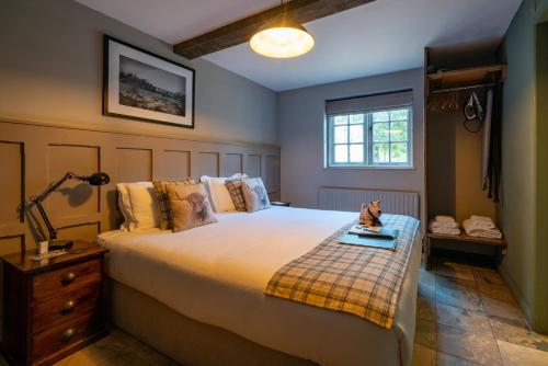 a bedroom with a bed and a lamp and a window at Bourne Valley Inn in Saint Mary Bourne