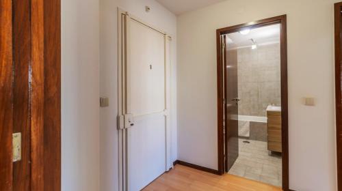 baño con una puerta de cristal que conduce a una ducha en Charmy Engenheiro António Costa Reis Apartment, en Senhora da Hora