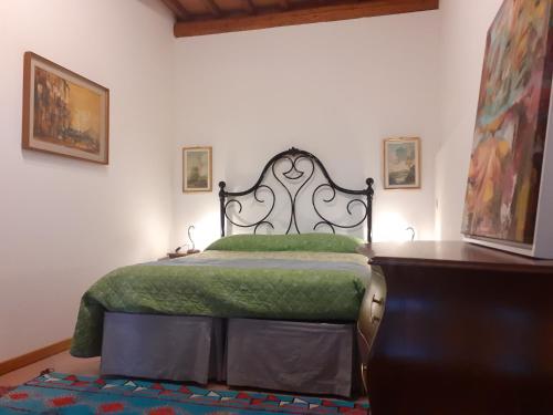 a bedroom with a bed with a green blanket at Agriturismo Podere Zollaio in Vinci
