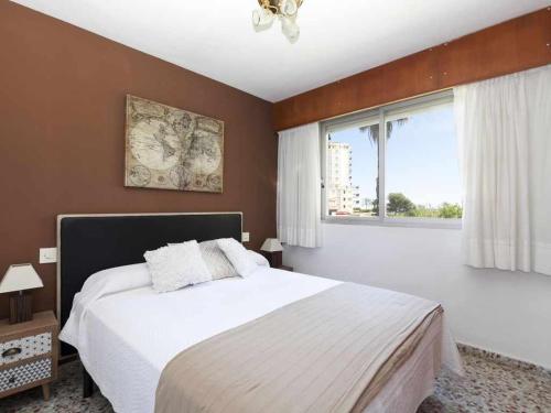 um quarto com uma cama grande e uma janela em Olimpia playa gandia em Playa de Gandia