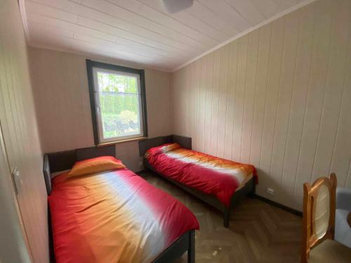 two beds in a small room with a window at Agroturystyka Gajewo in Suchowola