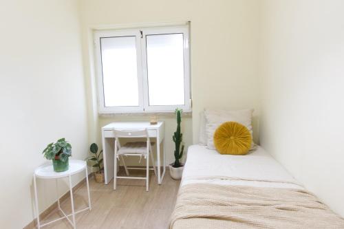 a bedroom with a bed and a table and a window at Alvalade CoLiving Hub in Lisbon