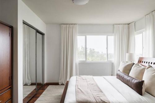a bedroom with a bed and a large window at Solana Beach Home 4 blocks from the Ocean in Solana Beach