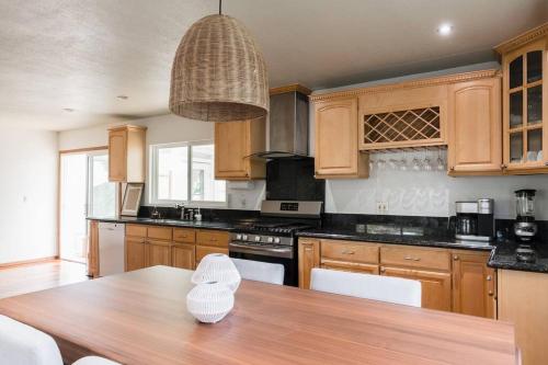 a kitchen with wooden cabinets and a wooden table at Solana Beach Home 4 blocks from the Ocean in Solana Beach