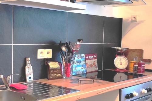 eine Küchentheke mit einer Arbeitsplatte mit einem Herd und einer Uhr in der Unterkunft Appartement de caractère in Munster