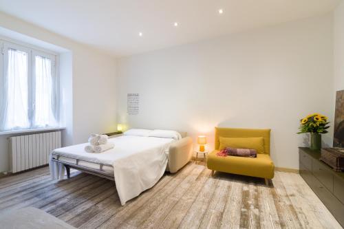 a bedroom with a bed and a yellow chair at Splendido Appartamento con 2 camere da letto in Milan