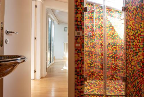 y baño con ducha de mosaico y aseo. en Al Cassero, en Perugia