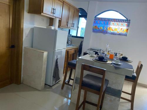 a kitchen with a white refrigerator and a table with chairs at Apartamento JGB in Sosúa
