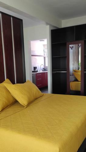 a bedroom with a bed with a yellow blanket at "Loft Naranjos, live the unique" in Oaxaca City
