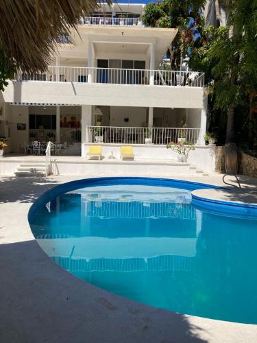 a large blue swimming pool in front of a house at Villa Covadonga in Acapulco