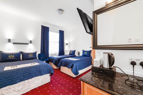 Habitación de hotel con 2 camas y TV de pantalla plana. en Jubilee Hotel Victoria, en Londres